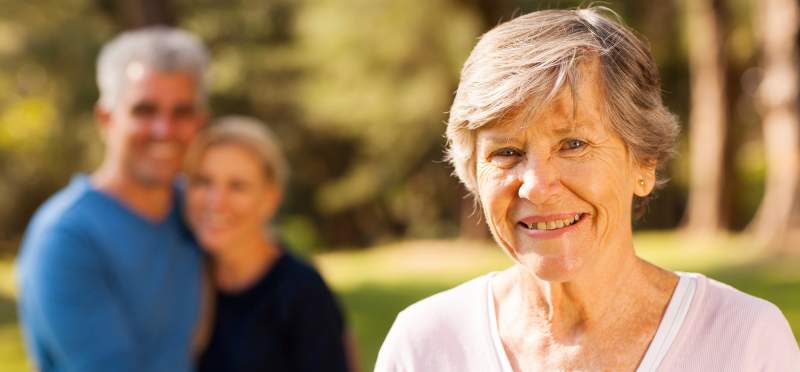 Senior with family in background